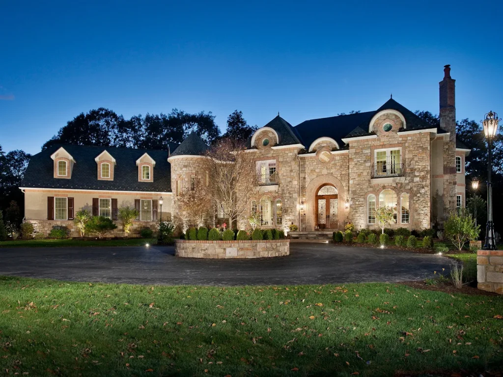 a big stone home lit up in the evening.